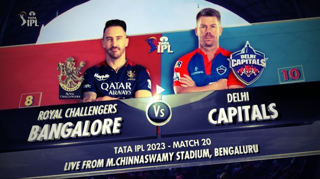 "The image shows two cricket experts engaged in a pre-match analysis of the game between Royal Challengers Bangalore and Delhi Capitals. They are sitting in a TV studio, with a green screen behind them displaying team logos and statistics. The experts are analyzing the strengths and weaknesses of both teams and making predictions about the game.